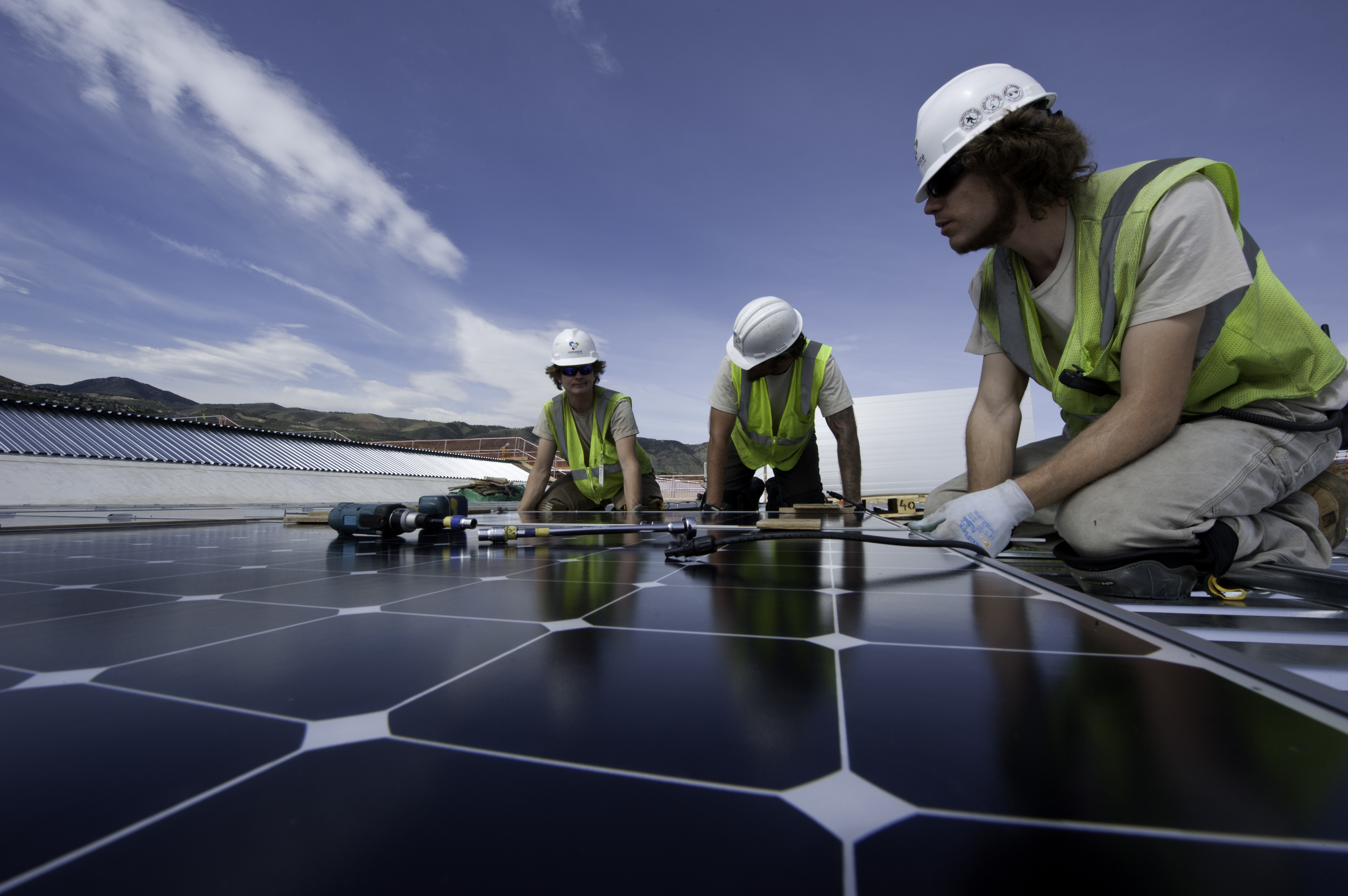 Solar workers install PV modules at NREL (Credit: Dennis Schroeder, NREL, 2012)